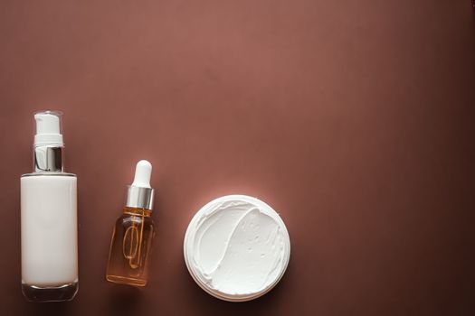 Skincare cosmetics and anti-aging beauty products, luxury skin care bottles, oil, serum and face cream on brown background