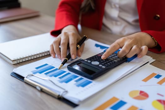 Bookkeeper calculating figures in company financial documents with a calculator, analysis of company financial data, Planning to assess and review budgets, concept of finance and investment