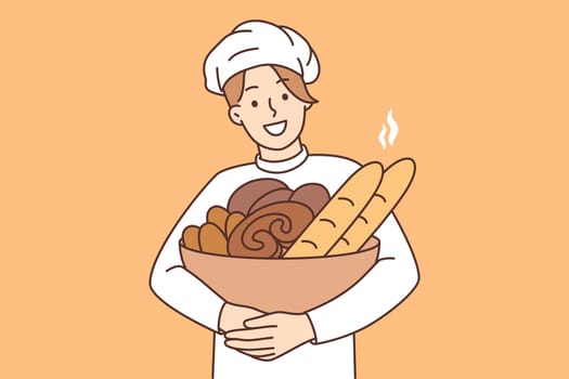Smiling male baker with basket of fresh bread