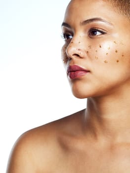 Youre pure gold. Studio shot of a beautiful young woman posing with glitter freckles on her face.