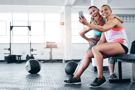 First gym buddies, now best friends. two young women taking a selfie at the gym.