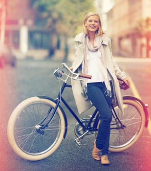 Travel by bike, youll miss all the traffic. Full length portrait of an attractive young woman leaning against her bicycle in the city.