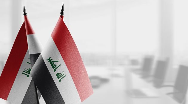Small flags of the Iraq on an abstract blurry background.