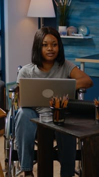 Invalid black person with laptop computer designing artwork