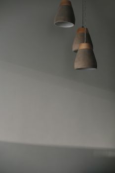 Fancy hanging lamps with wooden parts on the white wall background indoors. texture, copy space