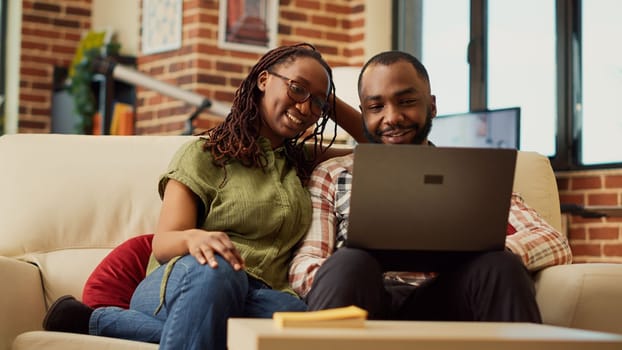 African american couple watching video on laptop together
