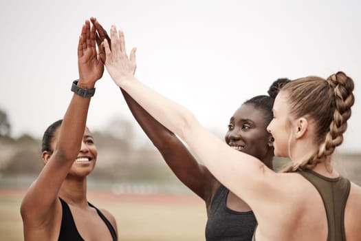 Believe in your abilities. a group of female athletes high fiving one another.