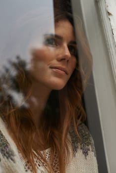Thoughts far away...Closeup shot of a beautiful young woman staring out through a window.