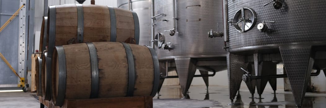 Huge tanks in wine cellars and wooden barrels of wine or alcohol