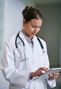 Making informed decisions about your health. a young doctor using a digital tablet at work.