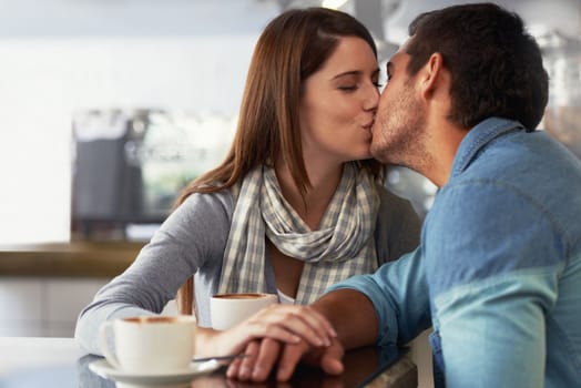 Showing her affection. A loving young couple at a coffee shop together.