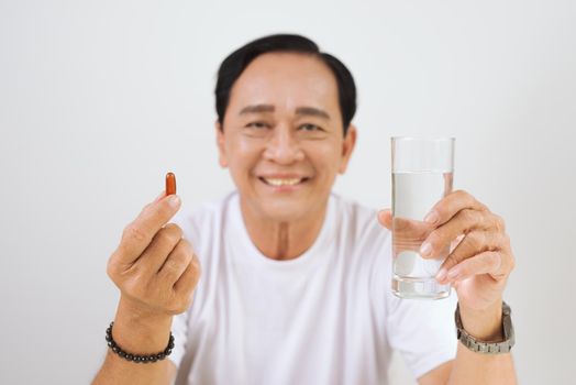 Elderly ill man with vitamin / omega 3 in hands.
