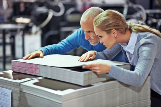 Determined to achieve perfection. two colleagues inspecting inventory in a printing factory.