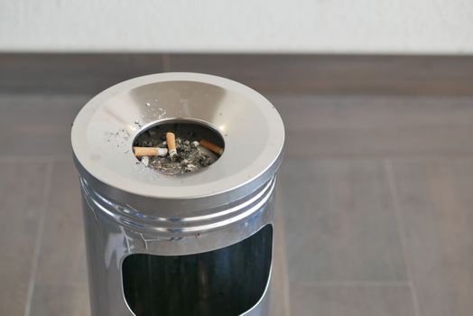 Close up burning cigarette in ashtray on table