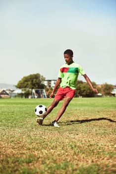 Check out his fancy footwork. a young boy playing soccer on a sports field.