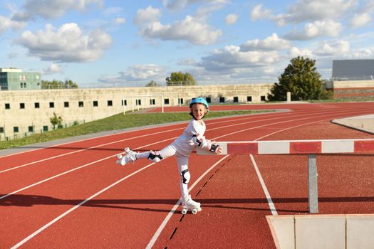 A girl in vintage white roller skates and a helmet at the stadium
