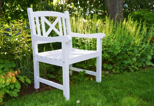 Springtime in the garden. Garden with white chair in springtime.
