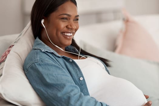 Enjoying some chill time during her maternity leave. a pregnant woman listening to music while relaxing at home.