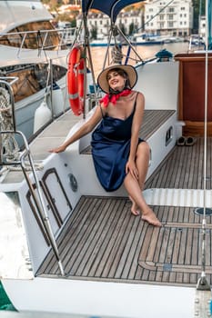 Woman yacht sea. Young happy woman in a blue dress and hat on a yacht. Travel and vacation concept