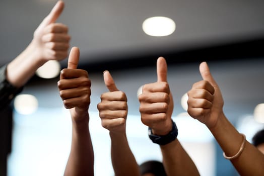 We appreciate you. a group of unrecognisable businesspeople showing thumbs up in a modern office.