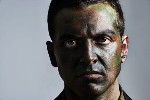 Ready for war. A young military man wearing camouflage facepaint.