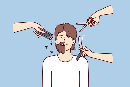 Hands with scissors and shaving devices around man with partially trimmed beard