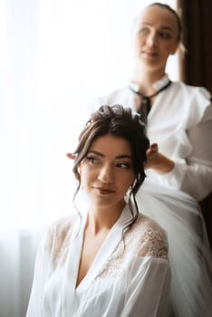 make-up artist makes a wedding look to the bride with makeup