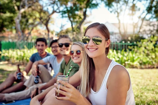 This is what summer is all about. Cropped portrait of an attractive young woman enjoying a few drinks with friends outside in the summer sun.