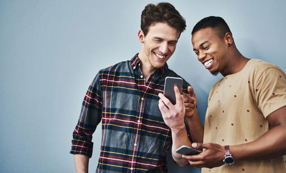 Did you see this post. Studio shot of two young men using a mobile phone together against a gray background.