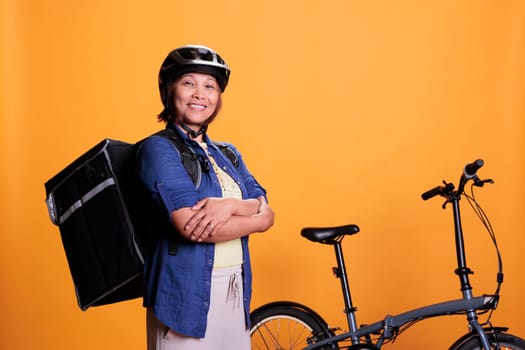 Deliver person carrying food delivery backpack standing beside bike