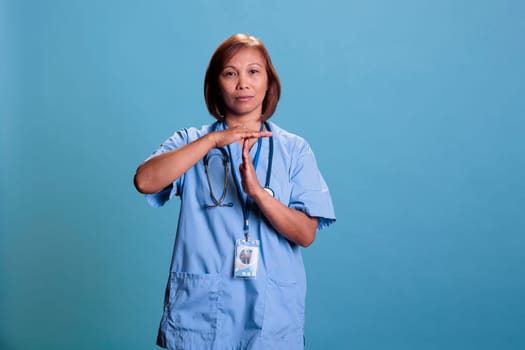 Asian medical assistant doing stop sign with hands while working at disease expertise