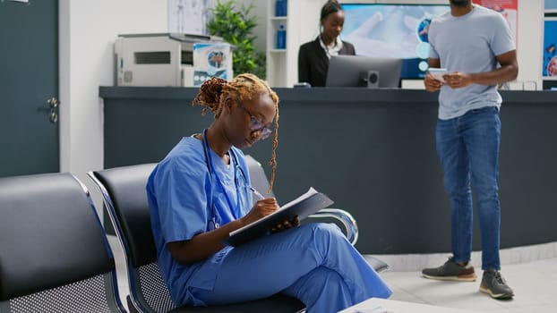 Medical assistant anayzing checkup forms in waiting room