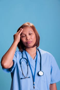 Tired nurse having migraine while working at medical expertise