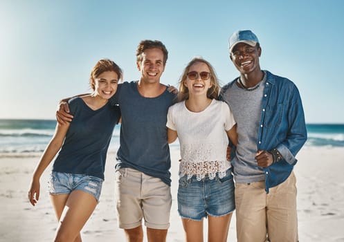 Friends make everything more fun. Portrait of a group of happy young friends posing on the beach together