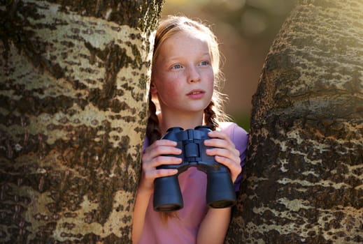 Adventure is out there. a little girl with a pair of binoculars in the outdoors.