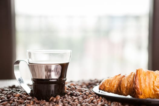 Croissant and coffee beans in close up