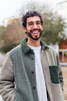 young man with beard laughing looking at camera