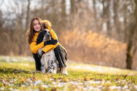 portrait of a happy young girl with her dog in nature. english setter
