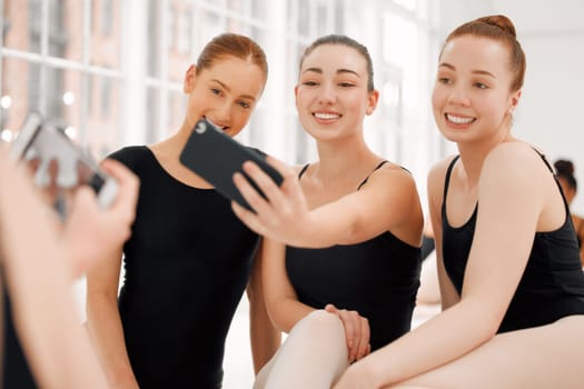 A city clique with hearts like trampolines. ballerinas taking selfies together with a smartphone with relaxing on break.