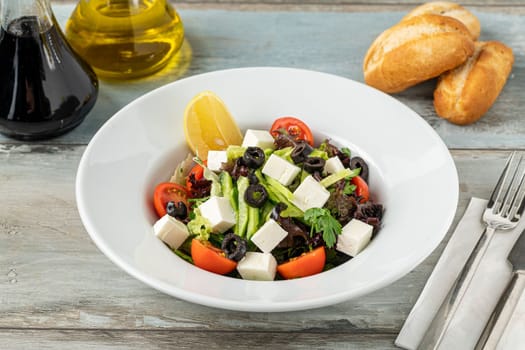 Mediterranean salad with olives and cheese on a white porcelain plate