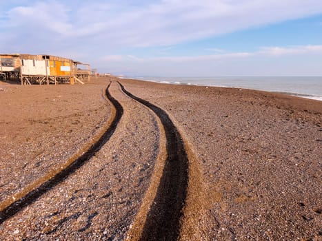 Wheel track of a 4x4 vehicle driving past the beach at sunset