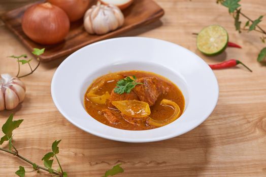 Chicken curry with spice on wooden background