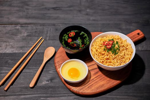 Instant noodles with egg in wooden bowls
