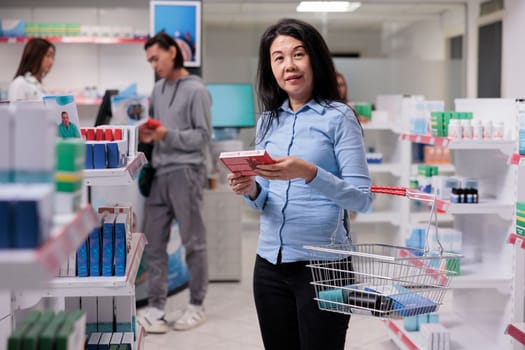 Happy asian customer looking at medicament boxes