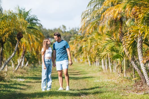 Family of daughter and father having fun among palm trees on vacation. Family vacation