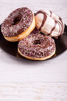 Different type of donuts on white wooden background
