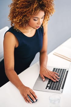 Managing her business relationships online. a young businesswoman working on a laptop at her desk.