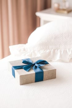 Holiday present and luxury online shopping delivery, wrapped linen gift box with blue ribbon on bed in bedroom, chic countryside style