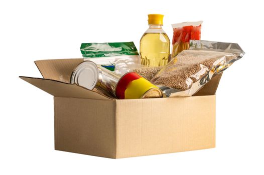 Foodstuff for donation isolated on white background with clipping path, storage and delivery. Various food, pasta, cooking oil and canned food in cardboard box.