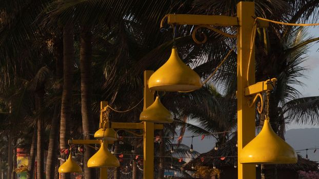 Close-up of yellow street lights on the beachfront promenade in the evening
